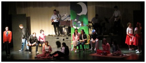 (Image: A Radio Announcer Speaks while Cast Members
 Occupy Various Locations in Town)