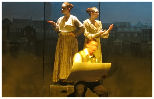 (Image: Bert Draws on an Artist's Pad while Seated
 in front of two Park Statues that are on a Pedestal)