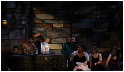 (Image: The Prisoners Watch Quixote
  as He Fights a `Giant' Off Stage.)