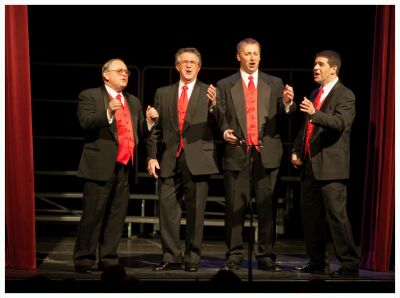 (Image: A Quartet Performs between Partially Closed Curtains)