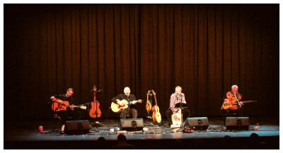 (Image: The Four Band Members Seated under Bright Lighting)