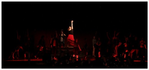 (Image: Two Principles on an Upstage Platform
        while the Chorus Kneels Facing It)