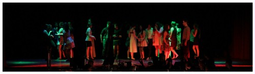 (Image: The Cast at a Party in Green and Orange
        Lighting)