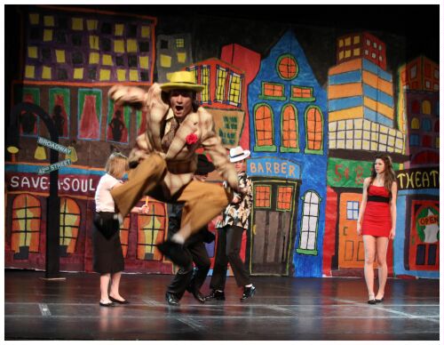 (Image: A Cast Member is Caught in Flight as
 he Leaps from the Stage to the House Floor)