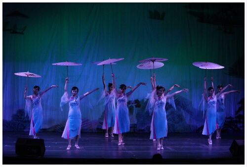 (Image: Eight Dancers Dressed in White Chiffon Hold Parasols
  Aloft)