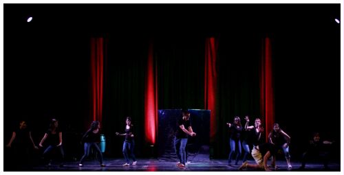 (Image: The Cast Downstage of the
  Mirrors with Red Columns of Light Behind)