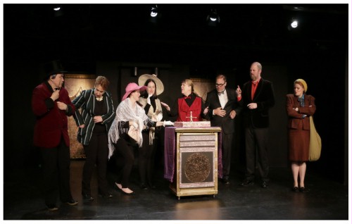 (Image: A Gambling Casino Croupier takes Bets
   for Roulette while the Cast looks on)
